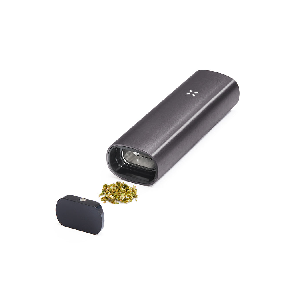 PAX 2 Dry Herb Vaporizer with body and removable mouthpiece shown beside ground botanical material, highlighting its sleek, pocket-sized design and intuitive features.