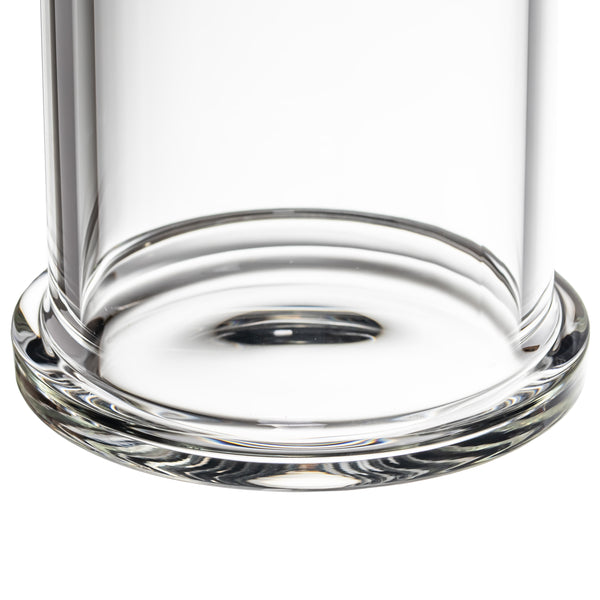 Close-up of MJ Arsenal Piston Gravity Bong's base, showcasing its clear borosilicate glass construction and precision-engineered, piston-inspired design on a white backdrop.