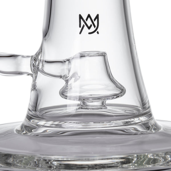 Spire - Clear: Close-up of a polished glass water pipe's lower chamber with bell diffuser, etched logo, showcasing its sleek design and borosilicate craftsmanship.