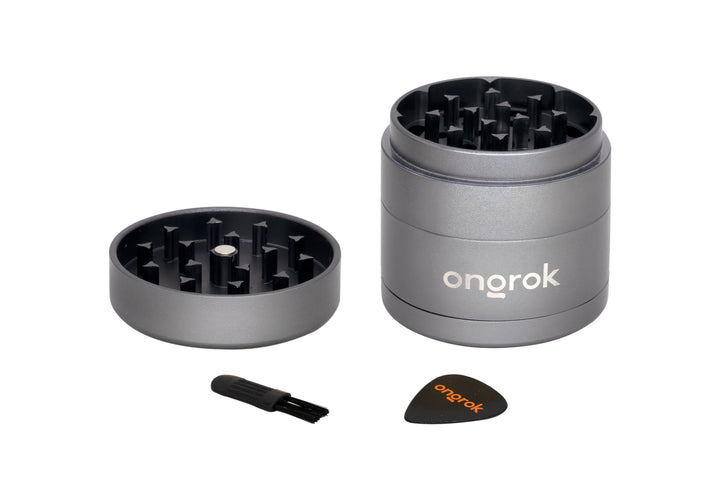 Mini EZ Grinder - 55mm: Disassembled 4-piece metal grinder with pyramid teeth, magnetic lid, and two accessories—a cleaning brush and scraper—for efficient herb processing.