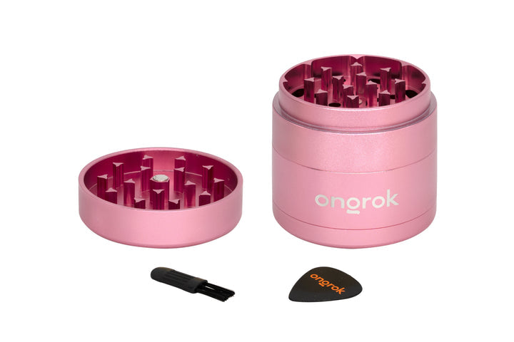 Mini EZ Grinder - 55mm with pink metal body, includes a tiny brush and plastic scraper for cleaning and efficient herb grinding and storage.