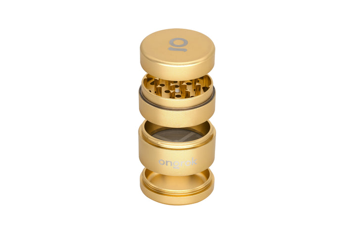 Mini EZ Grinder - 55mm: gold metallic four-piece grinder with magnetic lid, interlocking teeth, mesh screen, and collection chamber for herbs. Branded Ongrok for efficient grinding.