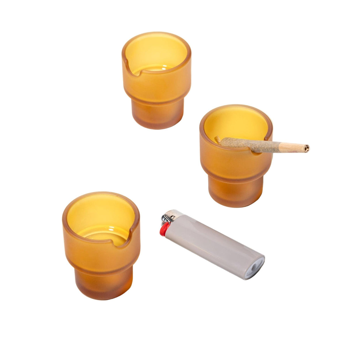 Flower Pots Ashtray Set: Four amber frosted glass cups with notches, one holding a pre-rolled joint, accompanied by a refillable lighter.