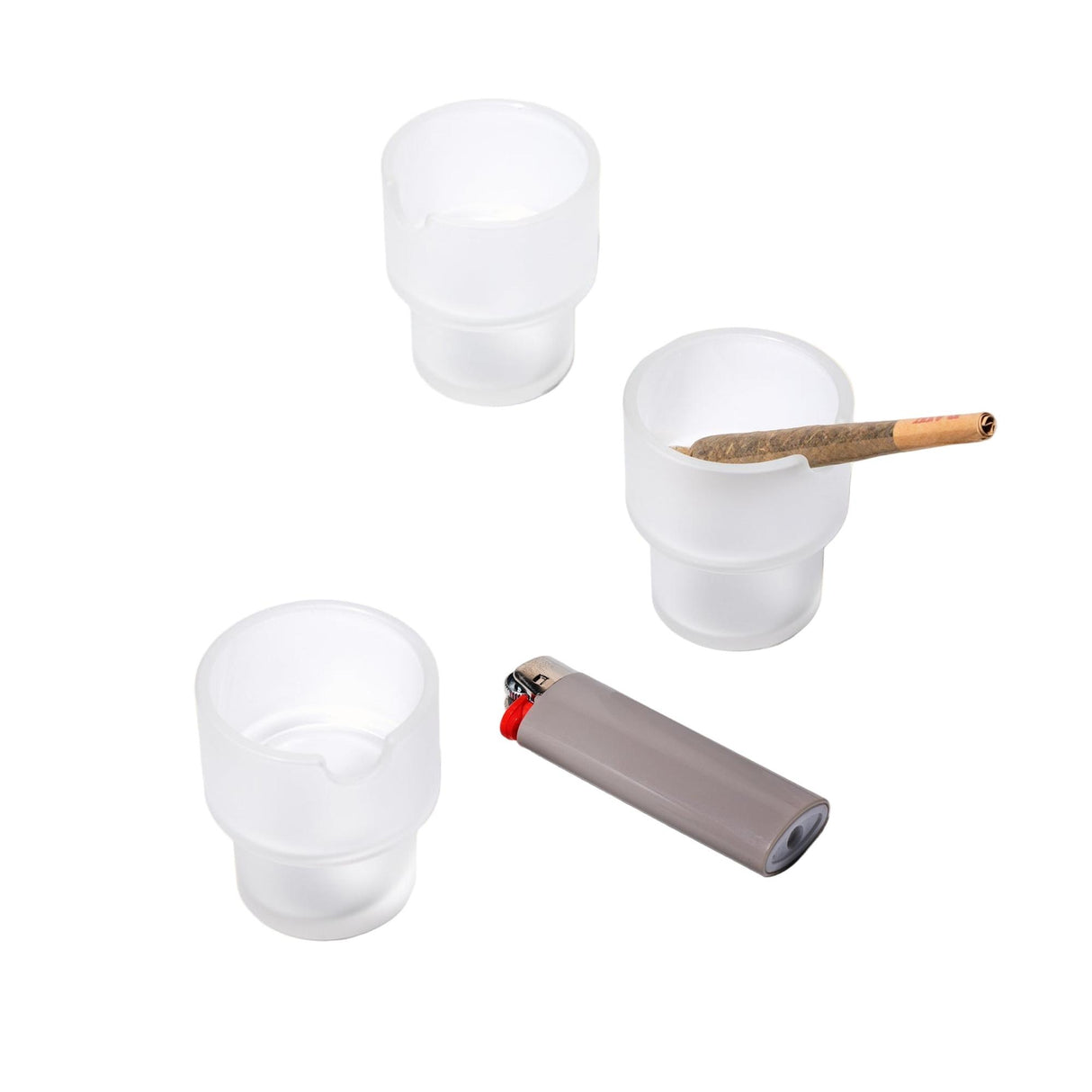 Three frosted-glass Flower Pots Ashtray Set cups with notches, one holding a joint, and a lighter nearby, showcasing functional art in modern design.