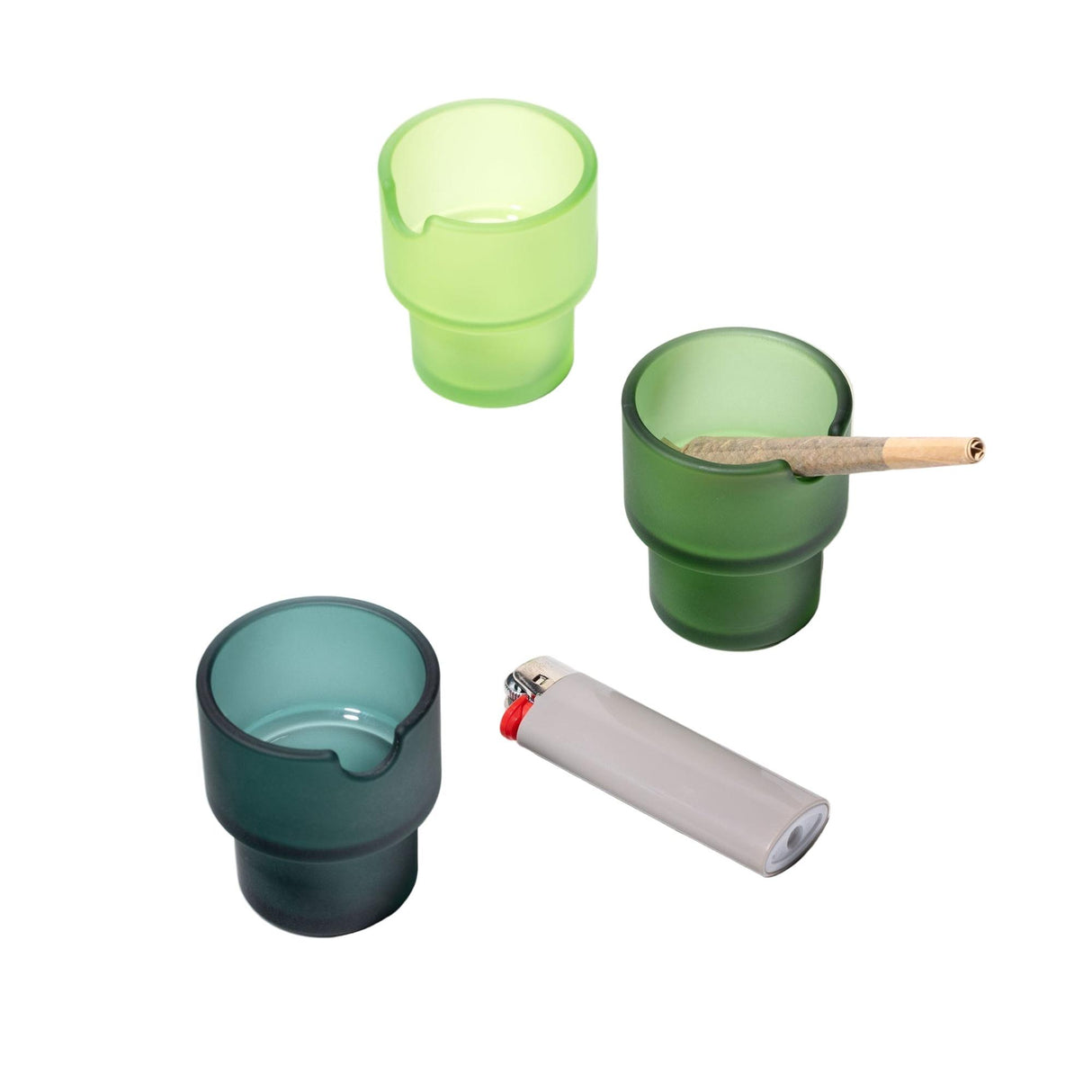 Three frosted-glass Flower Pots Ashtray Set cups, featuring notched rims and one holding a joint, adjacent to a lighter, showcasing functional art.