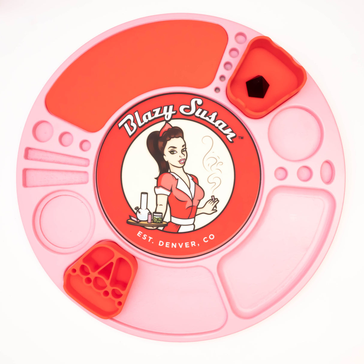 Pink silicone Spinning Rolling Tray with molded compartments and red catch-cups, featuring the Blazy Susan logo of a pin-up waitress with smoking accessories.