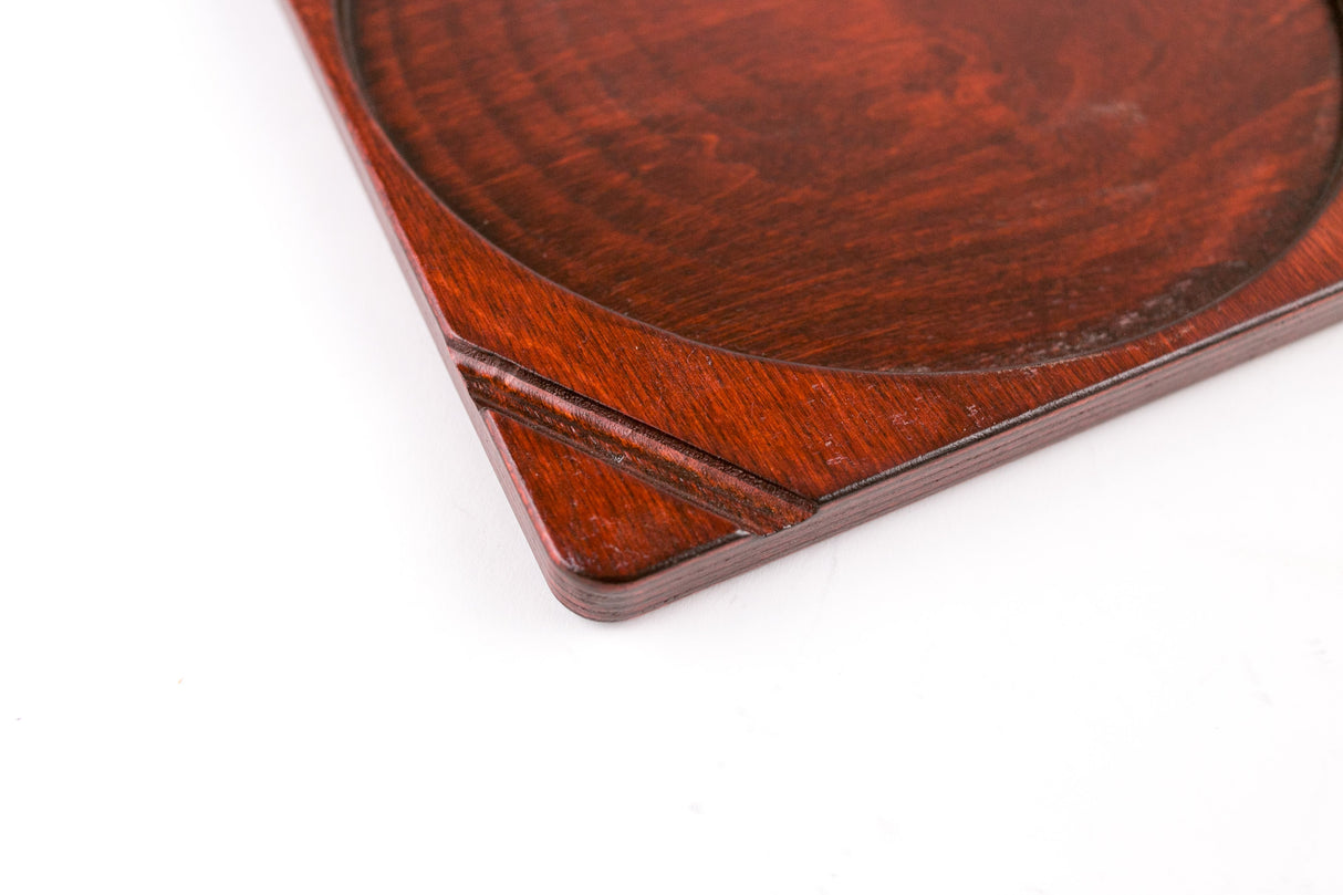 Close-up of the Blazy Susan Dab Tray corner, showcasing its reddish-brown birch wood with a carved circular recess, highlighting its organized, low-profile design.