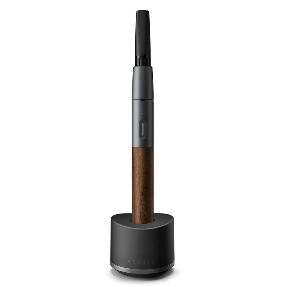 Craftsman 510 Thread Battery - Slate/Walnut, showcased in its charging dock, featuring a walnut wood finish, mouthpiece, button/battery section, and USB magnetic charging port.