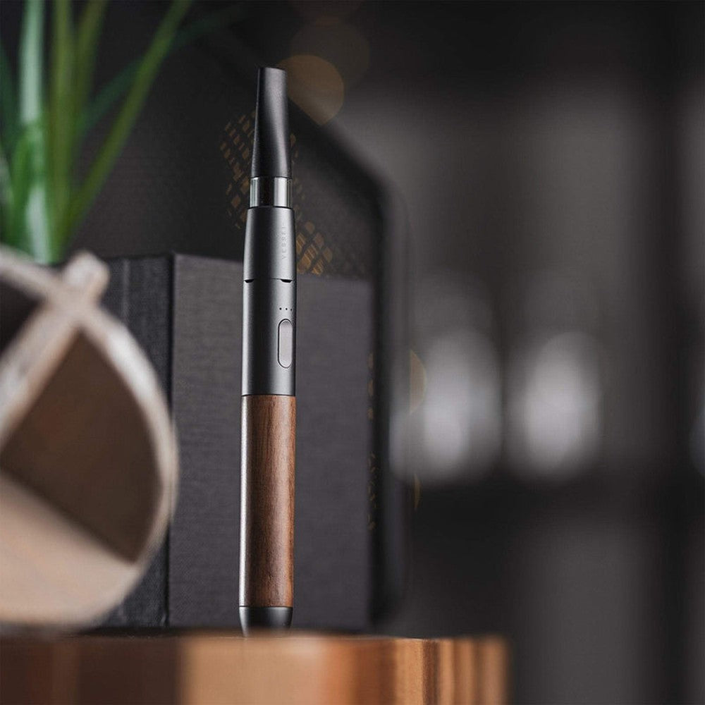 Craftsman 510 Thread Battery - Slate/Walnut: A slim, pen-style vaporizer with a metal and wood-grain body, single button, tapered mouthpiece, on a tabletop.