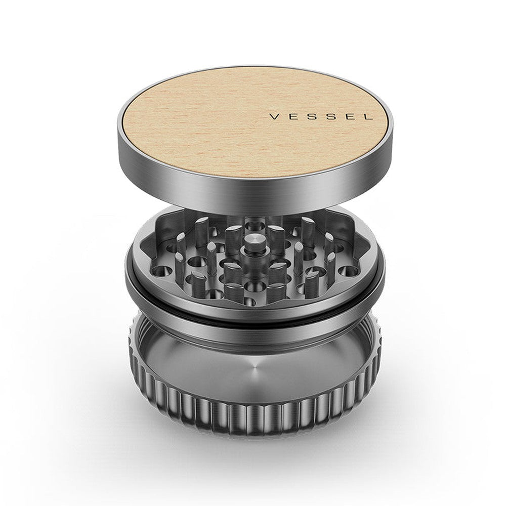 Vessel Mill Grinder, a 3-piece metal accessory with a wooden top, features a grinding section and catch-cup, ideal for precise herb preparation.