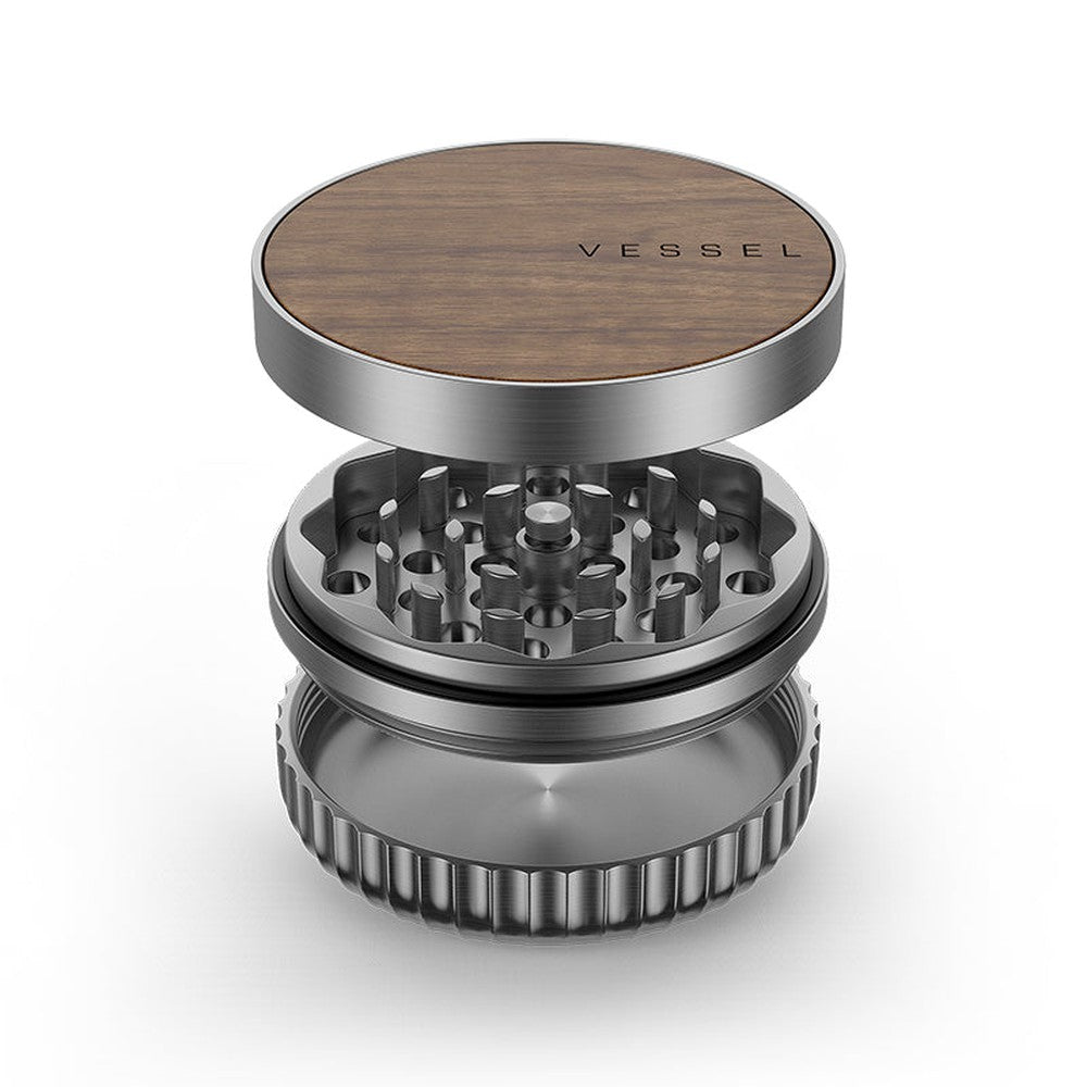 Vessel Mill Grinder with wood-veneer lid, visible grinding teeth, and catch chamber, showcasing its precision-engineered, three-piece aluminum design for dispensaries and headshops.