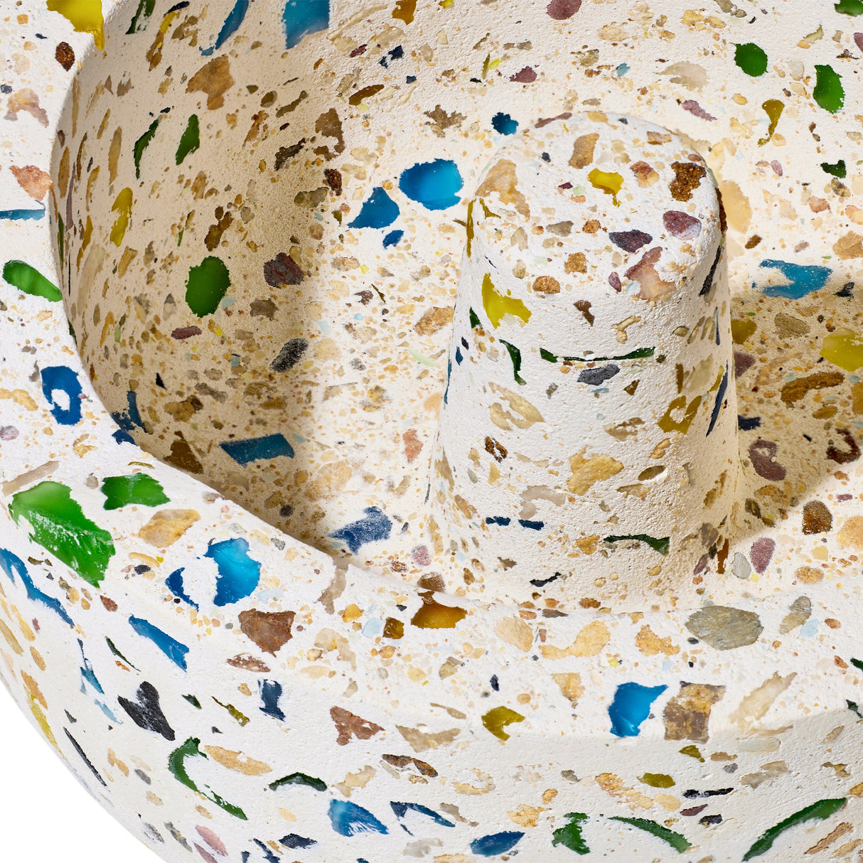 Symi Ashtray featuring terrazzo concrete with colored glass chips, shaped as a shallow bowl with a central cylindrical post, showcasing modern and vintage design.