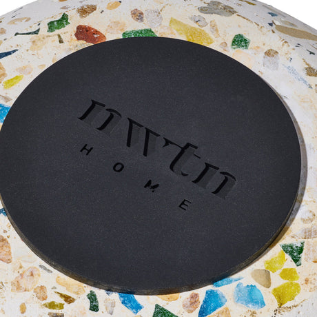 Close-up of Symi Ashtray's matte-black lid with MYNT HOME logo on a terrazzo surface, highlighting its sleek, modern design.