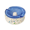 Symi Ashtray featuring a terrazzo-style concrete base with a swirled-blue glass insert, notched for cigarettes, highlighting its vintage-modern design.