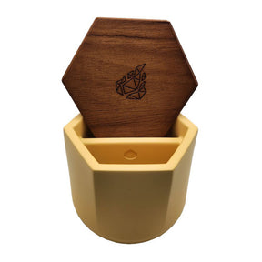 Malua Concrete Storage Jar with Walnut Lid, featuring a wooden coaster inside a yellow container, showcasing its stylish and functional design for cannabis storage.