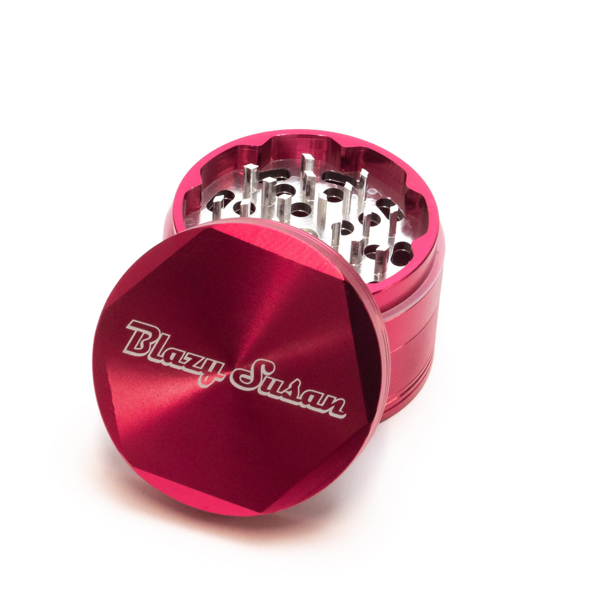 4-piece Aluminum Grinder 2.5 in bright red, showing sharp teeth and multi-chamber design, with the lid engraved Blazy Susan set aside.
