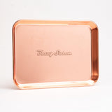 Stainless Steel Rolling Tray with raised edges, copper/rose-gold finish, and Blazy Susan embossed center, emphasizing durability and compact design for easy organization.