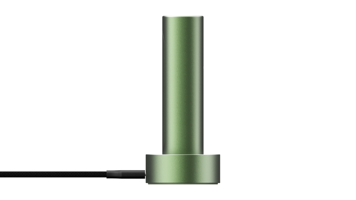 PAX FLOW vaporizer, a matte-green metal cylinder on a round base with a black braided power cable, showcasing its sleek, portable design.