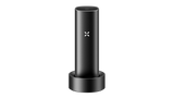 PAX FLOW vaporizer in charging cradle with visible PAX logo, showcasing its sleek, portable design and advanced technology for dry herb vaping.
