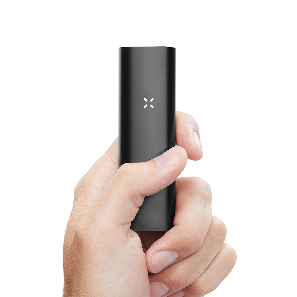 Hand holds matte-black PAX 3 Basic Kit, a slim, portable vaporizer with an X-shaped LED indicator, combining sleek design with advanced functionality.