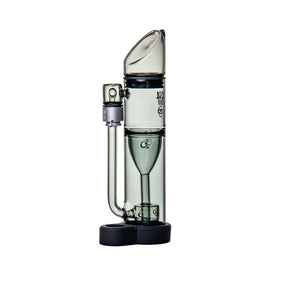 Ryan Fitt Pillar Pivot Top - Smoke: Compact borosilicate glass dab rig with slanted mouthpiece, sidecar-style joint, and silicone base for stability, designed for e-rig compatibility.