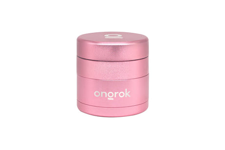 Mini EZ Grinder - 55mm: Compact cylindrical metallic pink grinder with a stylized O on the lid, featuring deep chambers and a magnetic locking system.