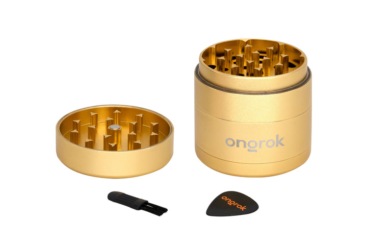 Mini EZ Grinder - 55mm, gold finish, disassembled showing grinding chamber, pollen catcher, with cleaning brush and scraper. Features interlocking teeth and smart storage design.
