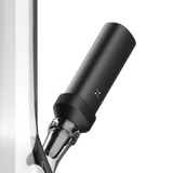 PAX FLOW Bong Adapter 2 - Black, a matte-black cylindrical module with a cross-shaped LED, attaches magnetically to a clear glass joint for smooth, cool vapor sessions.
