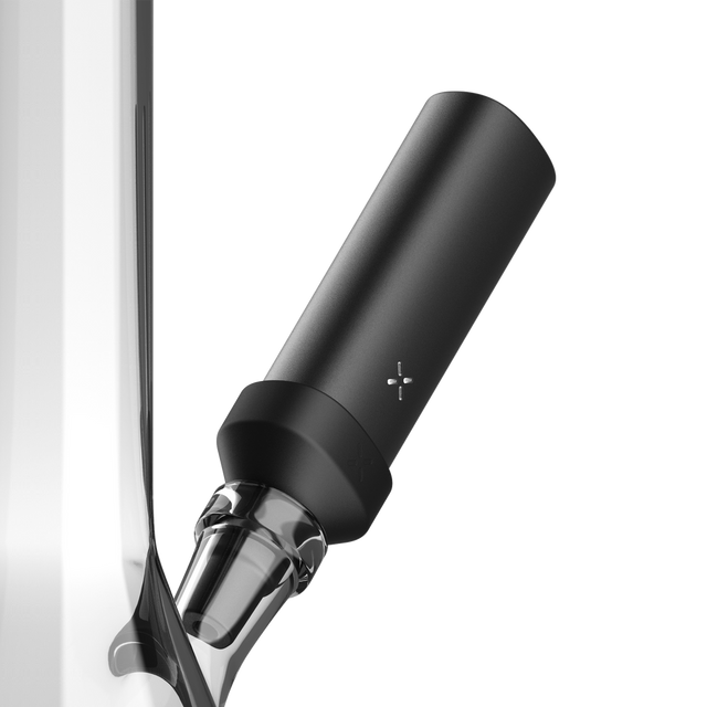 PAX FLOW Bong Adapter 2 - Black, a matte-black cylindrical module with a cross-shaped LED, attaches magnetically to a clear glass joint for smooth, cool vapor sessions.