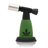 5 Blow Torch Turbo Flame with green body, black top, cannabis-leaf logo. Compact, ergonomic design ideal for precision tasks, offering a powerful 2500°F flame.