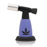 5 Blow Torch Turbo Flame with a metal burner head, purple body featuring a cannabis-leaf logo, and rubberized base, ideal for pipes and culinary use.