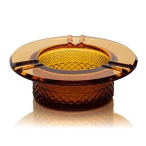 Twenties Collection Ashtray: Round, amber-colored glass with diamond-cut pattern, three rim notches for cigarettes, crafted from durable borosilicate glass for lasting use.