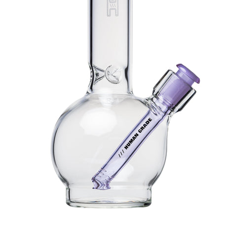 Clear glass water pipe with a round base, featuring a purple-tinted HUMAN GRADE downstem, 14mm, 4, set against a white background, appearing unused.