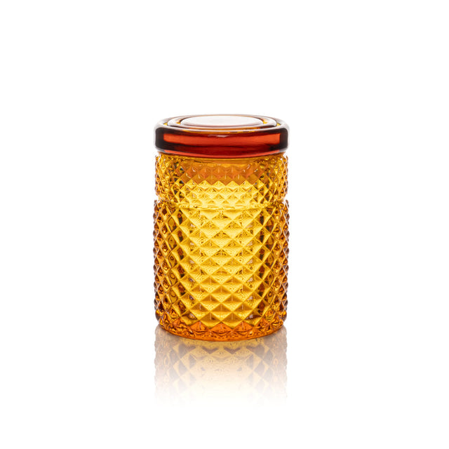 Twenties Collection Stash Jar: A small, amber, cylindrical borosilicate glass jar with raised diamond texture and airtight lid, designed for stylish, durable storage.