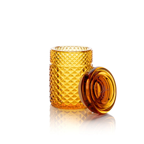 Twenties Collection Stash Jar: Cylindrical glass jar with diamond-cut pattern, matching lid beside it, showcasing its elegant design and durable construction for secure storage.