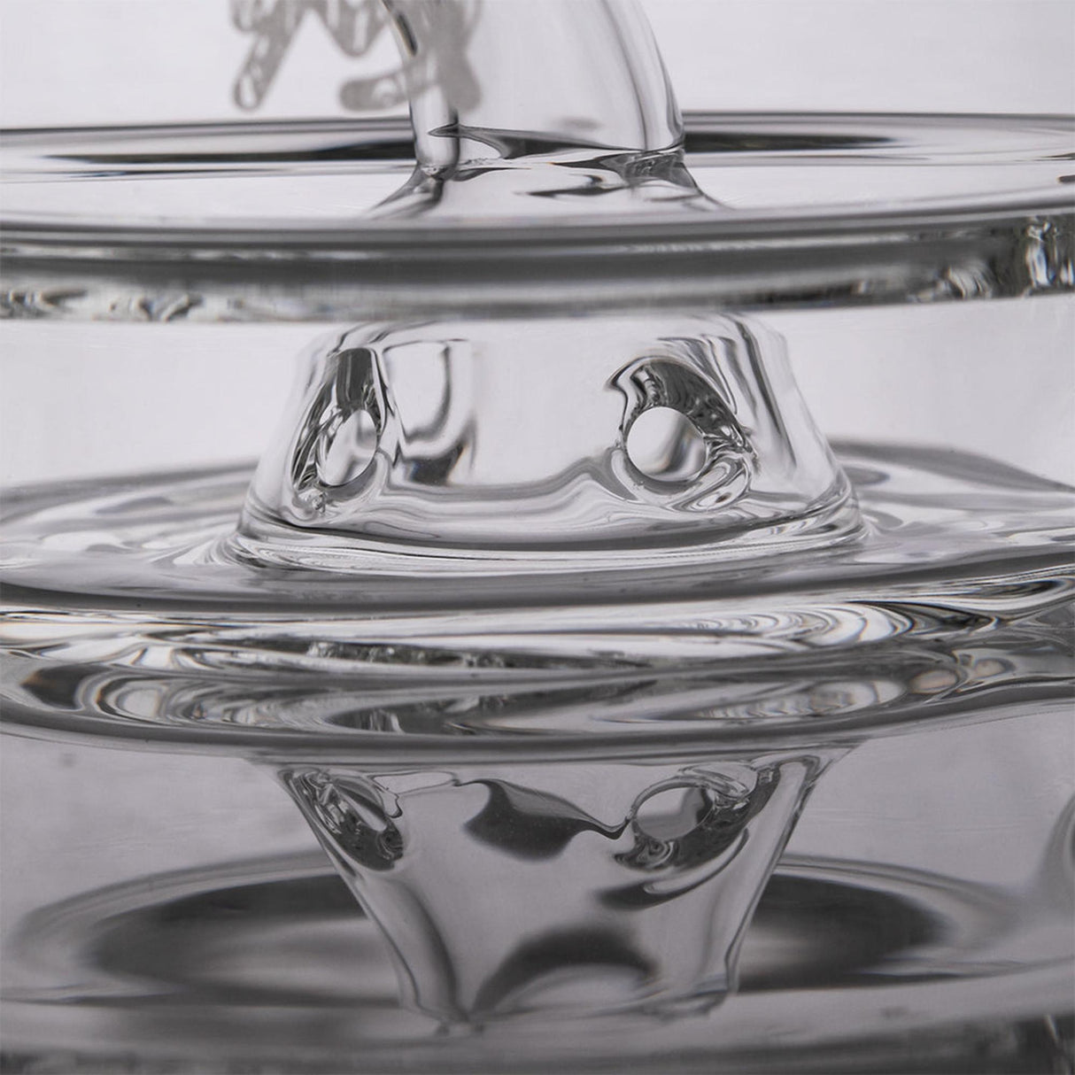 Close-up of Apex Mini Rig from the Alpine Collection, showcasing its transparent concentric glass rings and innovative design for smooth, flavorful draws.