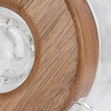 Close-up of the Apex Dab Rig - Alpine Collection, highlighting the milled black walnut ring accenting its glass surface for refined style and performance.