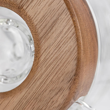 Close-up of the Apex Dab Rig - Alpine Collection, highlighting the milled black walnut ring accenting its glass surface for refined style and performance.