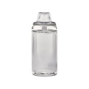 Deco Gravity Bong: A tall, cylindrical clear glass container with fluting, topped by a ribbed lid. Combines Art Deco elegance with modern gravity-powered functionality.