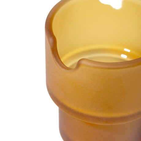 Close-up of the NWTN Home Flower Pots Ashtray, showcasing its amber-yellow frosted glass with a semi-circular notch, highlighting its elegant, sculptural design.