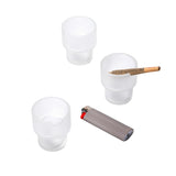 Three frosted-glass Flower Pots Ashtray Set cups with notches, one holding a joint, and a lighter nearby, showcasing functional art in modern design.
