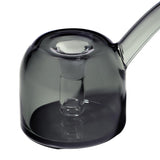 Close-up of the Vesper Bubbler, a smoke-grey glass vessel with an integrated infuser tube and curved handle/spout, showcasing its modern, elegant design.