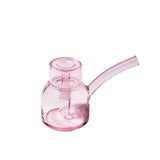 Vesper Bubbler: A compact, pink-tinted glass water pipe with a rounded chamber, downstem, and bent mouthpiece, showcasing modern design and effortless functionality.