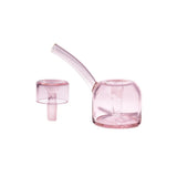 The Vesper Bubbler in translucent pink glass features a sleek, bent mouthpiece and a matching carb cap for controlled airflow and smooth, elegant use.