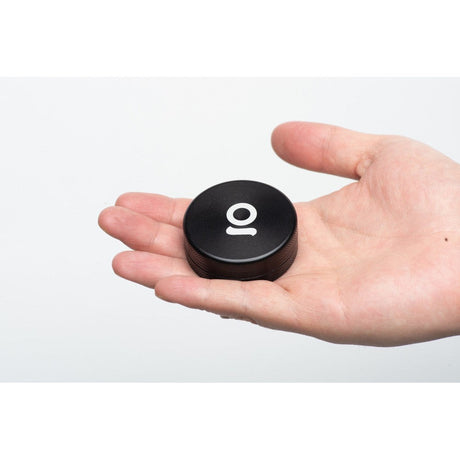 Hand holding the 2pcs Metal 2 Magnetic Grinder, showcasing its compact, round design and robust construction, ideal for efficient herb grinding.