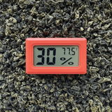 Digital Hygrometer - 6 pack on green leaves, displaying temperature and humidity; compact design with clear LCD for accurate monitoring in various storage solutions.