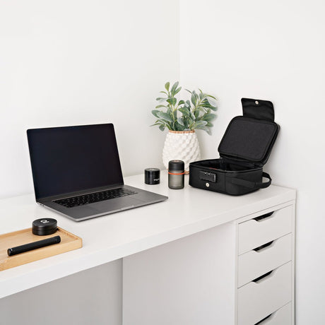 Large Smell Proof Case with Combo Lock sits open on a minimalist desk, showcasing its sleek travel-ready design and secure storage capabilities.