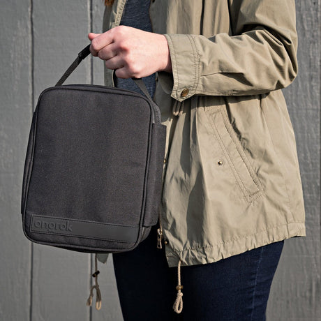 Person holding ONGROK Large Smell Proof Case with Combo Lock, showcasing its durable fabric, top handle, and rubberized logo. Ideal for secure, organized travel storage.