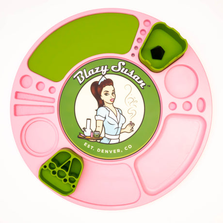 Spinning Rolling Tray by Blazy Susan: Round silicone tray with pink and green compartments, central logo of a waitress, and snap-in green insert cups for organizing cannabis accessories.
