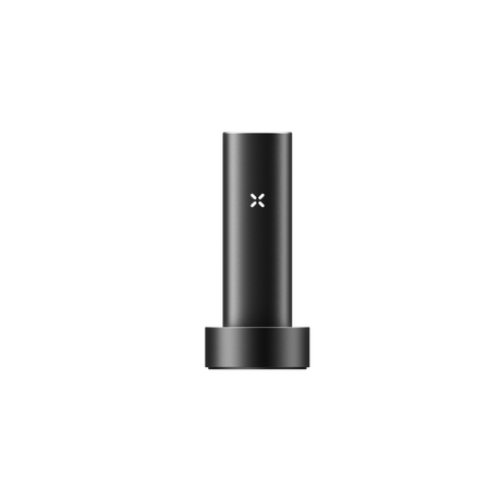 PAX FLOW vaporizer in matte-black, cylindrical design, resting in a round dock, featuring an illuminated “X” logo, highlighting its sleek, portable build.